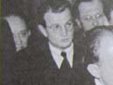 Vladimír Pelikán řečený Kosťa (1916–1980), syn olomouckého sochaře Julia Pelikána (1887–1869) a starší bratr Jiřího Pelikána (1823–1999), v letech 1963–1968 ředitele Československé televize, poté v emigraci v Itálii. Už jako středoškolák se angažoval v Komunistické studentské frakci (Kostufře) a posléze v KSČ, v letech 1940–1945 byl vězněn nacisty, medicínu dostudoval po válce na Lékařské fakultě MU. Specializoval se jako lékař-internista, na Lékařské fakultě UP v Olomouci, jejímž děkanem byl v letech 1960–1962, dosáhl doktorátu lékařských věd a profesury, po roce 1974 byl politicky perzekvován. Detail fotografie z 21. února 1947.